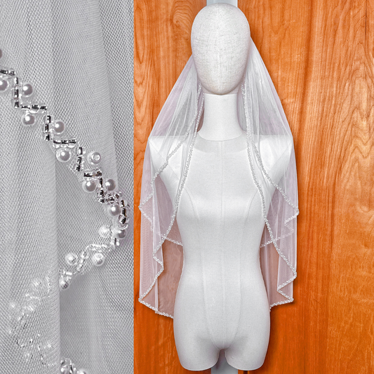 Beaded edge two tier wedding veil in hip length displayed on a bridal manniuqe.