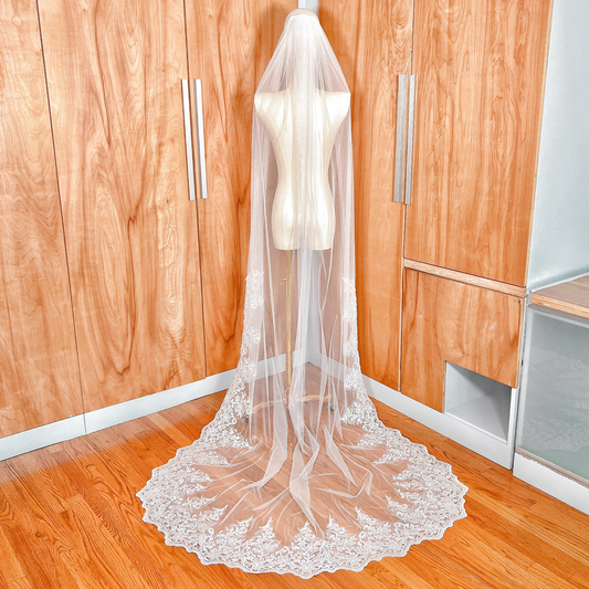 Back view of a beaded lace wedding veil in chapel length, demonstrating how the veil sweeps across the floor for a traditional bridal look.