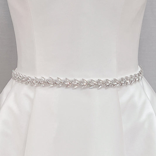 Elegant crystal rhinestone wedding dress sash and silver beaded bridal belt shown on a display mannequin.