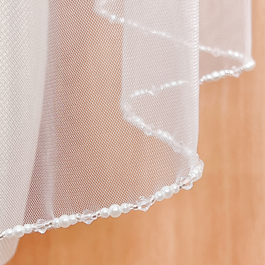 Pearl and crystal edge wedding veil in fingertip length.