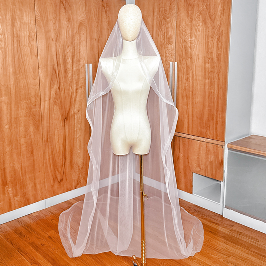 Cathedral length cascade wedding veil with 1.5 inch horsehair trim displayed on a bridal mannequin.