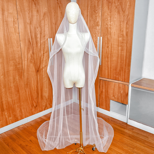 A full-length cathedral wedding veil with a cascading silhouette and 2-inch horsehair trim displayed on a mannequin.