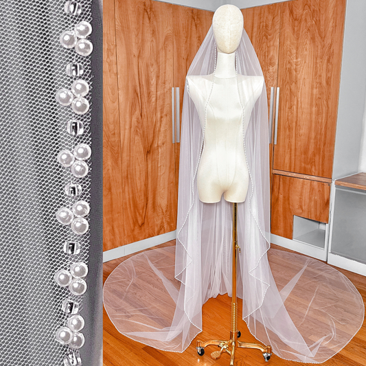 Front view of a cathedral length cascade wedding veil with a delicate beaded edge.