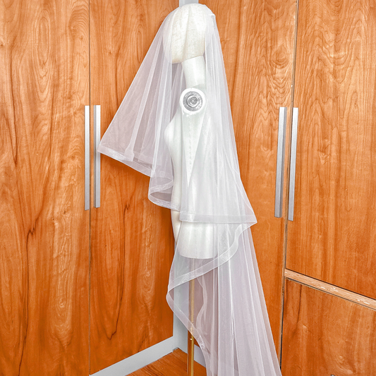 Side view of a 1 1/2" horsehair trim wedding veil with blusher at cathedral length on a mannequin.