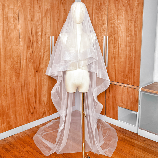 Front view of a two tier cathedral length wedding veil featuring a 3 inch horsehair edge and blusher.