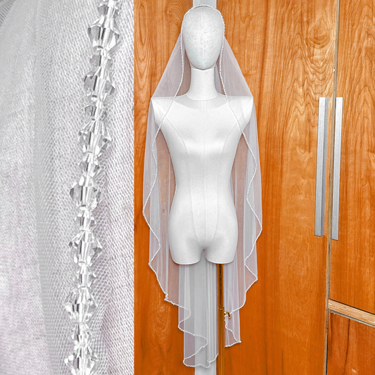 Front view of a crystal mantilla wedding veil in waltz length displayed on a bridal mannequin.
