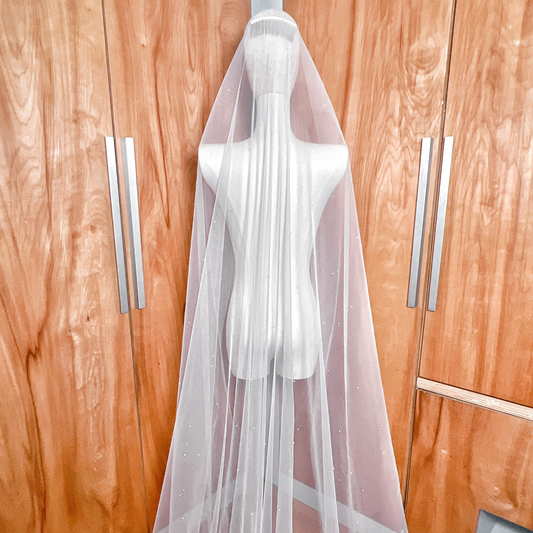 Luxurious ivory allover pearl wedding veil with a long cathedral train draped to show the intricate pearl design.