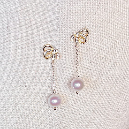 Bridal close-up pearl bowknot dangle earrings for wedding day jewelry.
