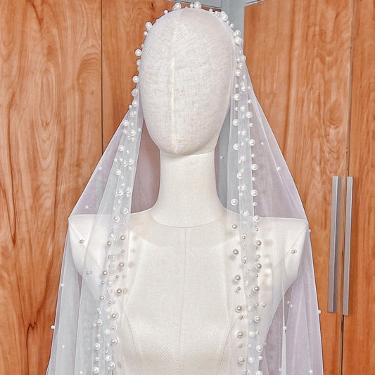 Side profile of the scattered pearl edge mantilla wedding veil in cathedral length shown on a mannequin to display the drape.