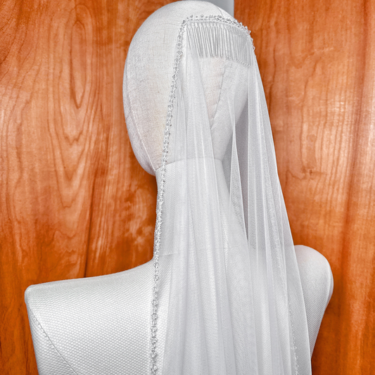 Hand-placed crystals sparkle on this waltz length mantilla wedding veil displayed on a bridal mannequin.