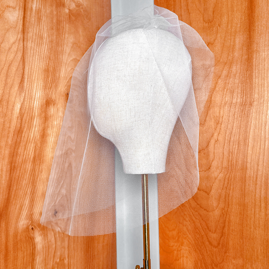Close-up view of the fine mesh pattern and finished edge of a tulle birdcage wedding veil.