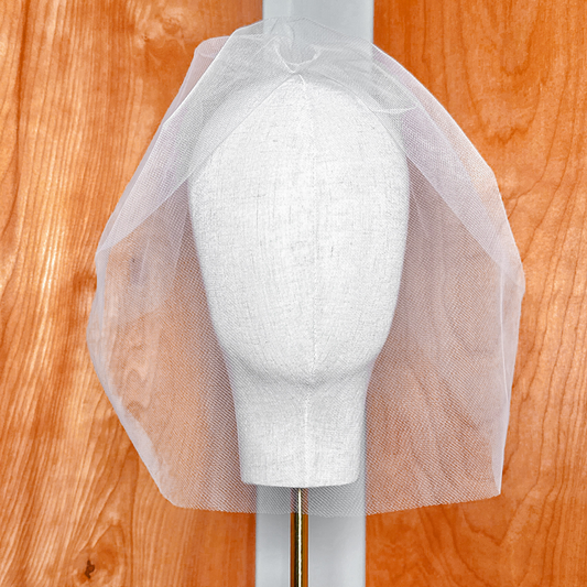Front view of the Tulle Birdcage Wedding Veil in Vintage Style for a Civil Ceremony, displayed on a bridal mannequin to show how the sheer netting drapes over the face.