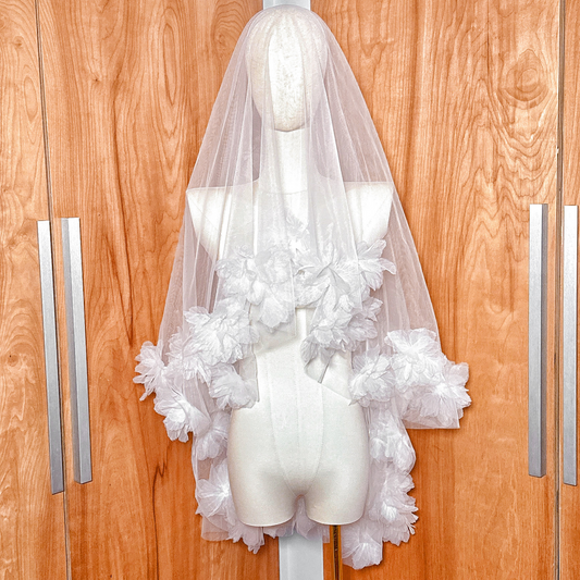 Front view of a two tier 3D flower wedding veil in fingertip length displayed on a bridal mannequin.