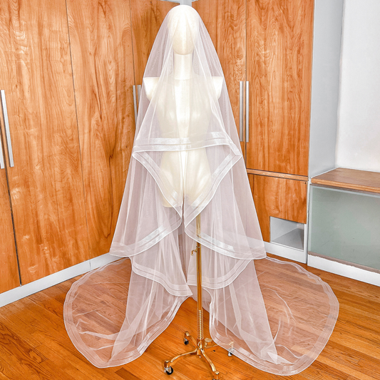 Front view of a two tier cathedral length wedding veil with elegant double horsehair trim displayed on a mannequin.