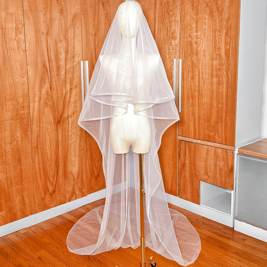Two-tier cathedral length wedding veil with 1/2 inch horsehair trim and blusher displayed on a mannequin.