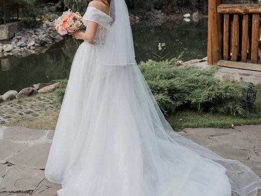 Two tier crystal beaded edge wedding veil with blusher in cathedral length on a bride.