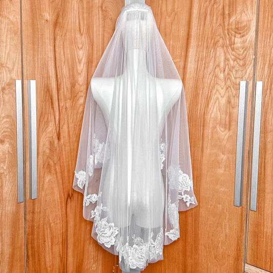 Back view of a two tier floral lace wedding veil in a fingertip length cut.