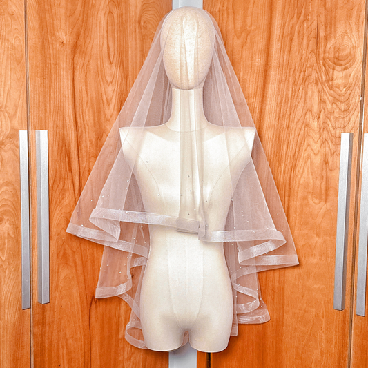 Front view of a two tier horsehair wedding veil with scattered rhinestones in fingertip length on a mannequin.