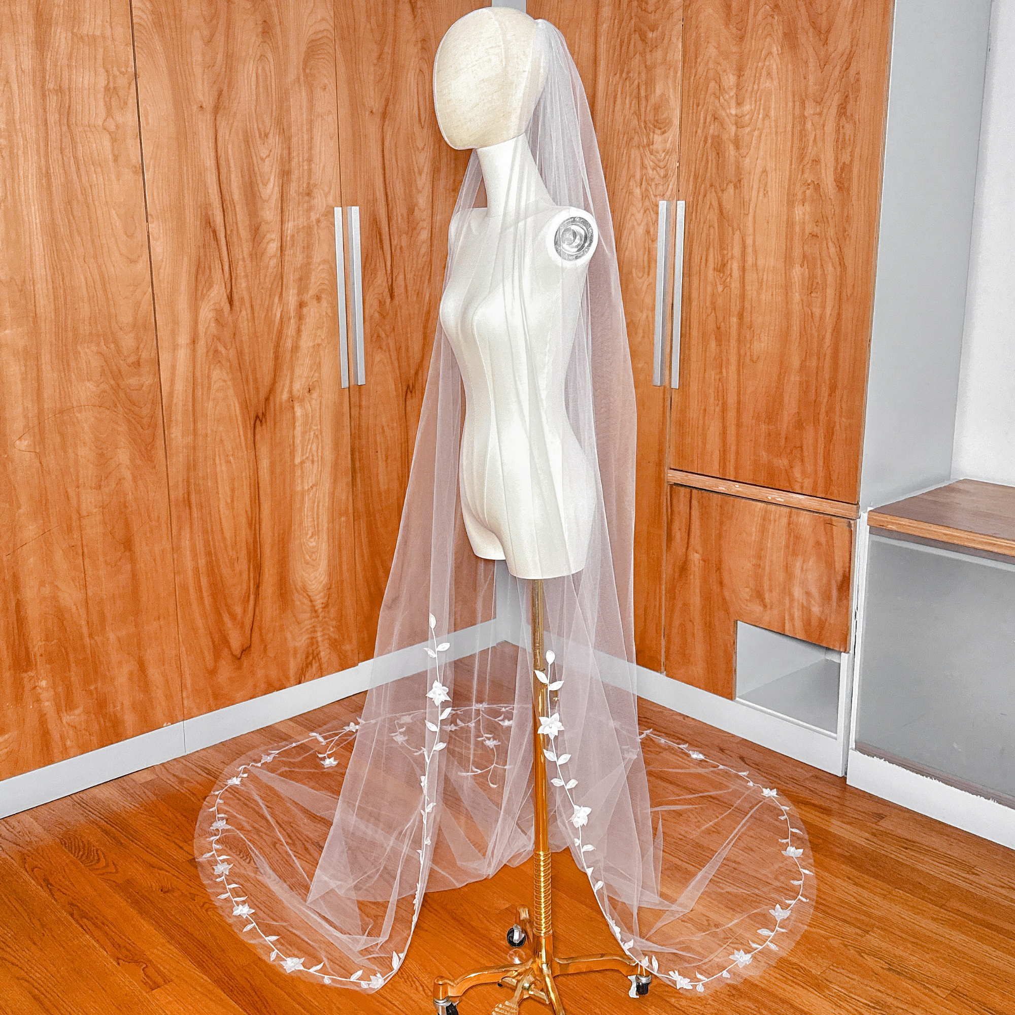 Side profile view of the mannequin showing where the delicate botanical embroidery begins gracefully at fingertip level before cascading downward.
