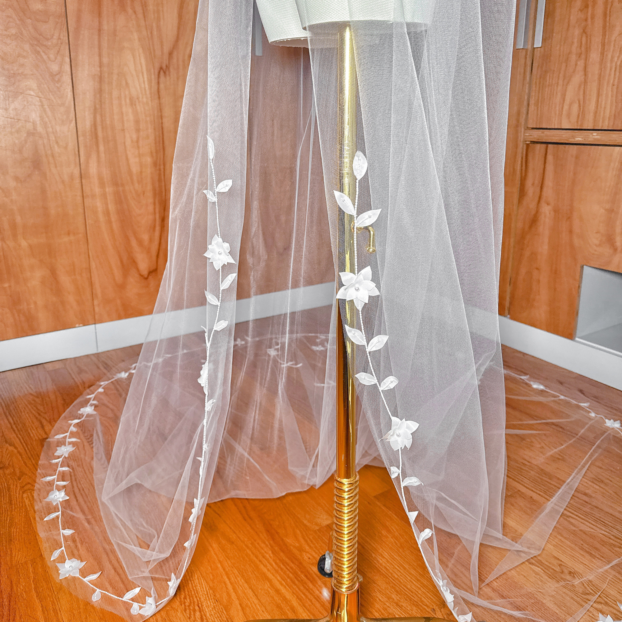 Macro shot focusing on the high-quality stitching, delicate leaves, and bead clusters along the edge of the translucent tulle.