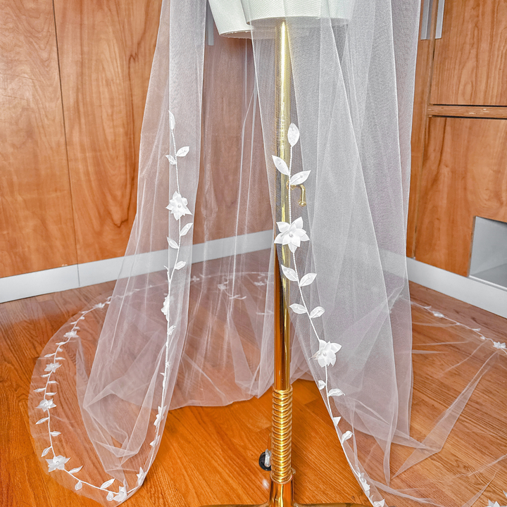 Macro shot focusing on the high-quality stitching, delicate leaves, and bead clusters along the edge of the translucent tulle.