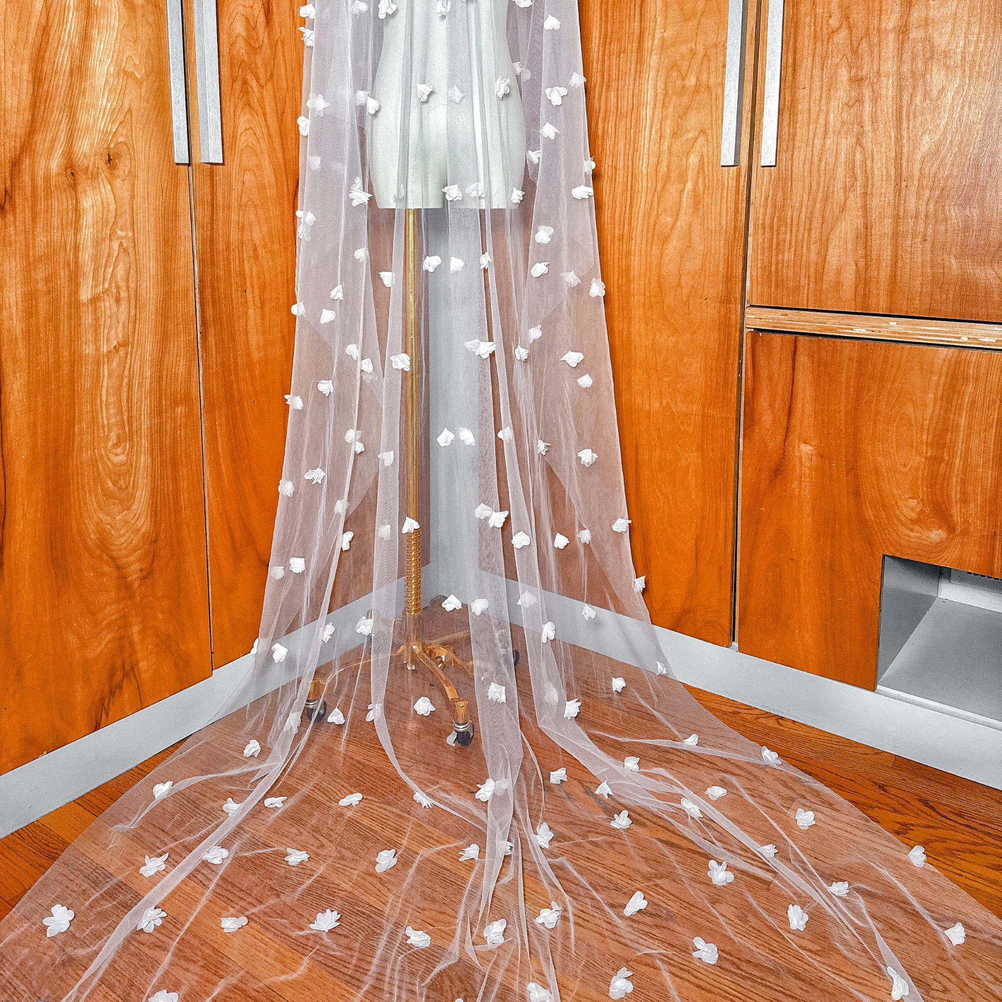 Close-up of 3D floral embroidery on a cathedral length two tier wedding veil with blusher.