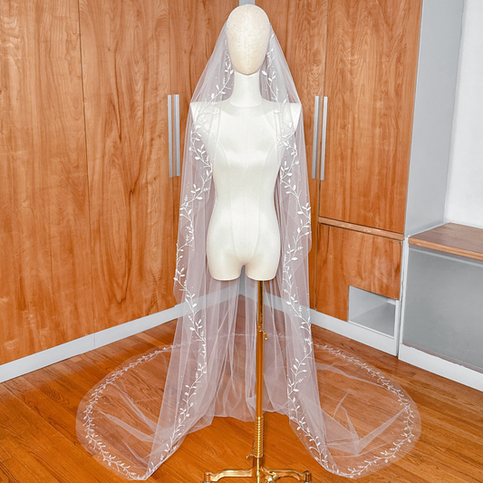 Cathedral length 3D silk leaf veil with a beaded vine edge displayed on a mannequin.