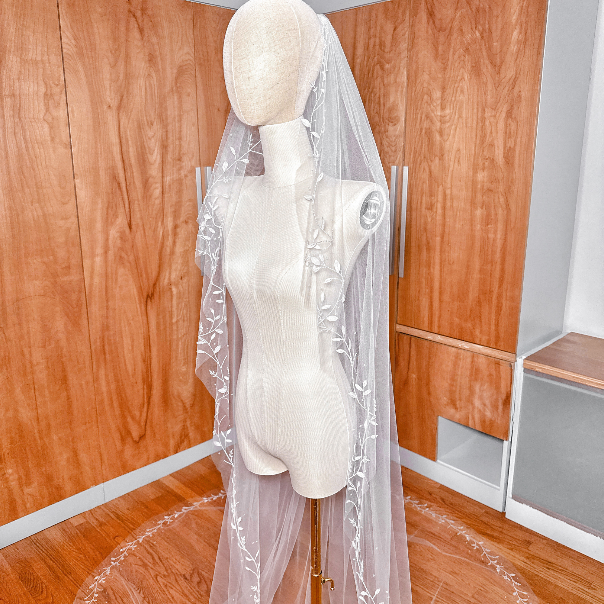 Detailed texture of 3D silk leaf floral appliqués on a soft bridal veil.