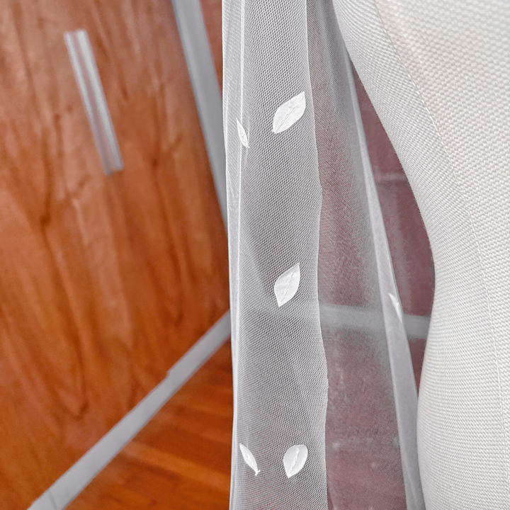 Close-up of intricate 3D silk floral petals hand-sewn onto a sheer cathedral length veil.