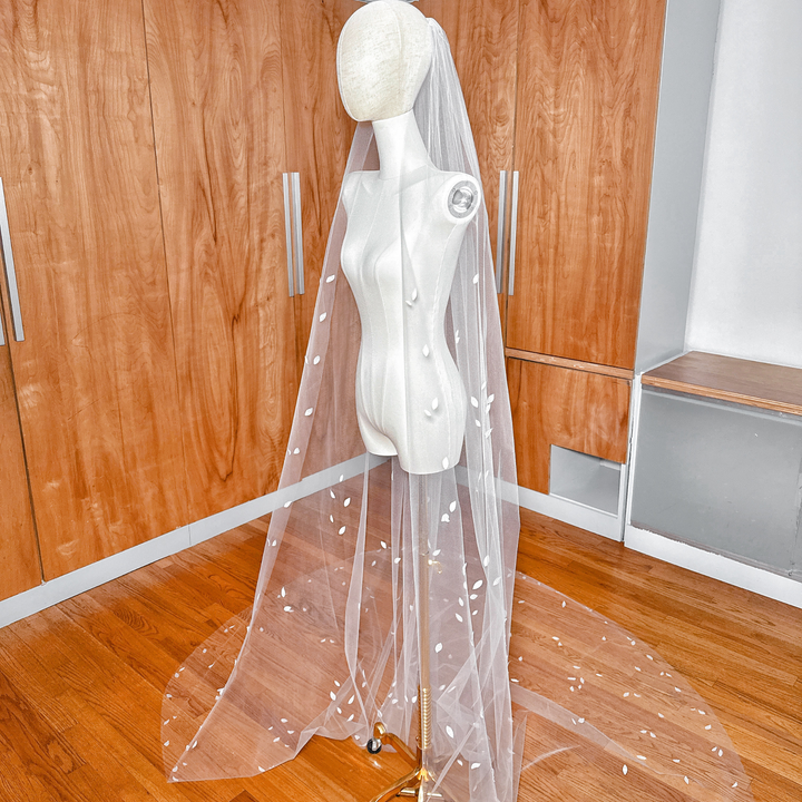 Side profile of a cathedral length 3D silk petal veil showing the elegant floral layering.