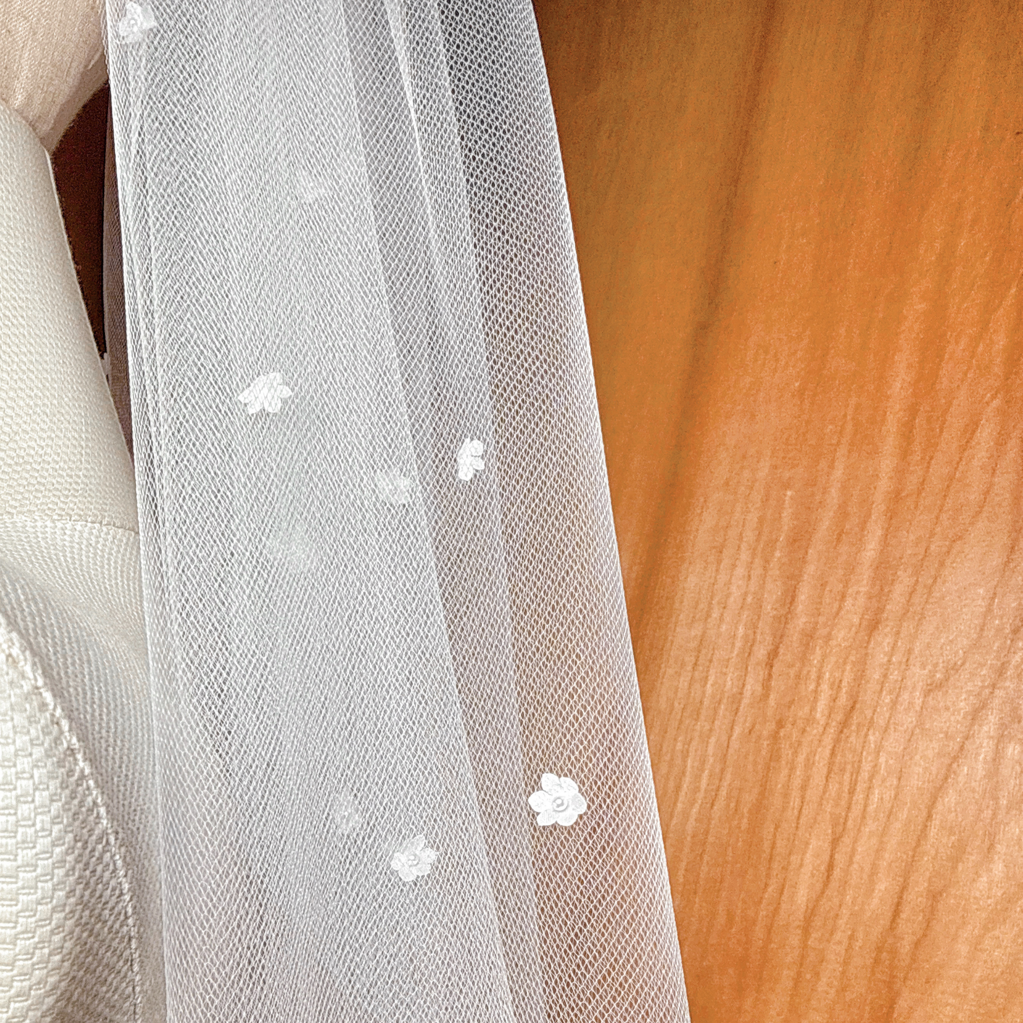 Close-up shot focusing on the intricate texture of the handcrafted 3D silk satin flowers and the central Swarovski pearls.
