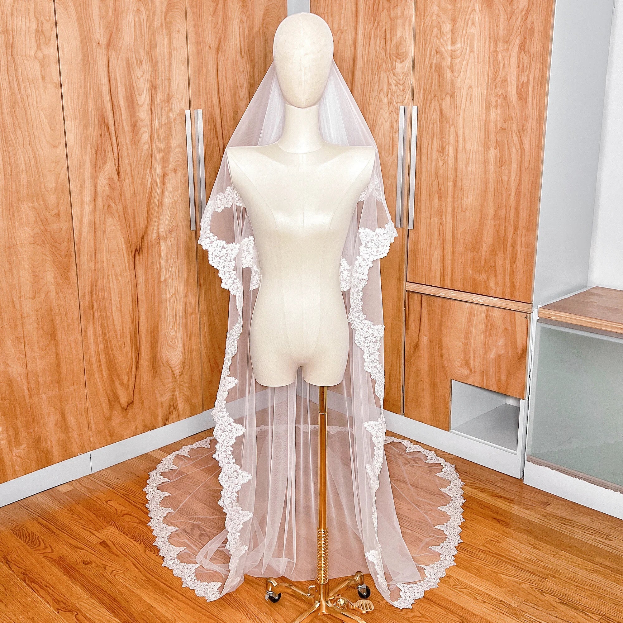 Detailed view of the intricate Alençon lace edging on a two-tier cathedral length wedding veil with blusher.