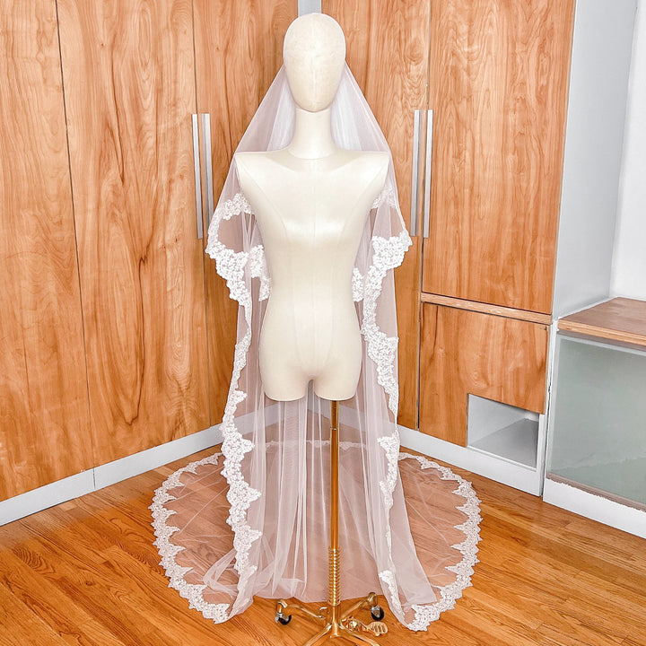Detailed view of the intricate Alençon lace edging on a two-tier cathedral length wedding veil with blusher.