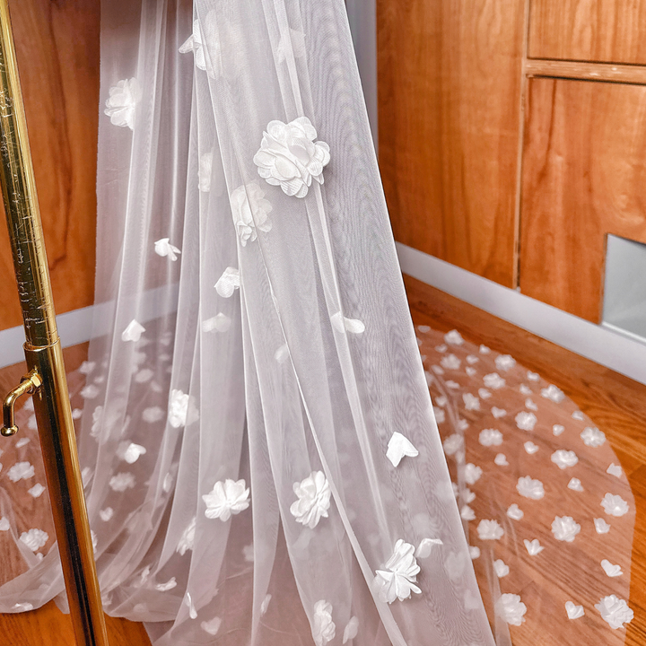 Close-up of dimensional petals on the allover 3D floral wedding veil cathedral length, highlighting the textured floral detail.
