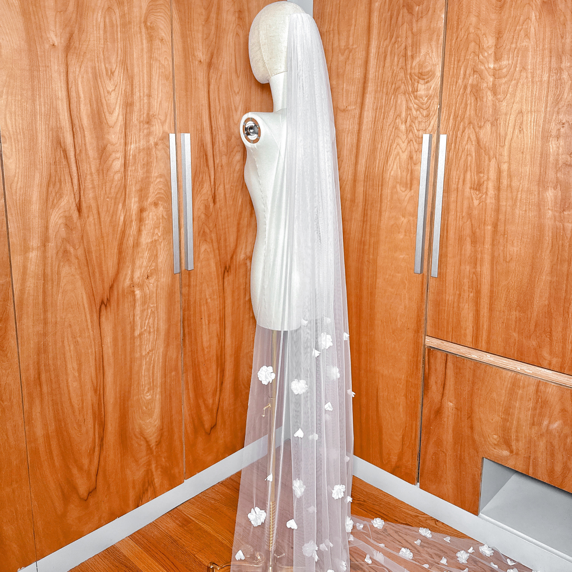 Top view of the allover 3D floral wedding veil cathedral length showing the secure metal comb attachment on the mannequin head.
