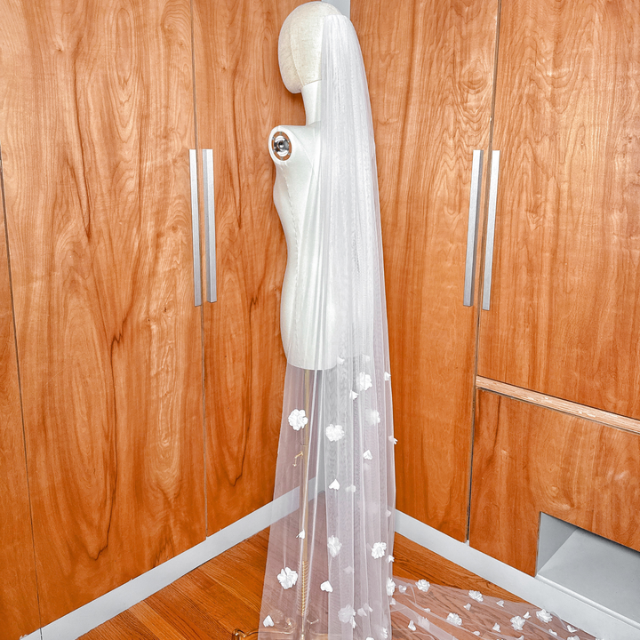Top view of the allover 3D floral wedding veil cathedral length showing the secure metal comb attachment on the mannequin head.