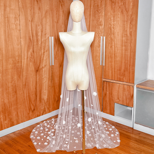 Wide shot of the allover 3D floral wedding veil cathedral length spread out at the base of a mannequin to show the full floral pattern.
