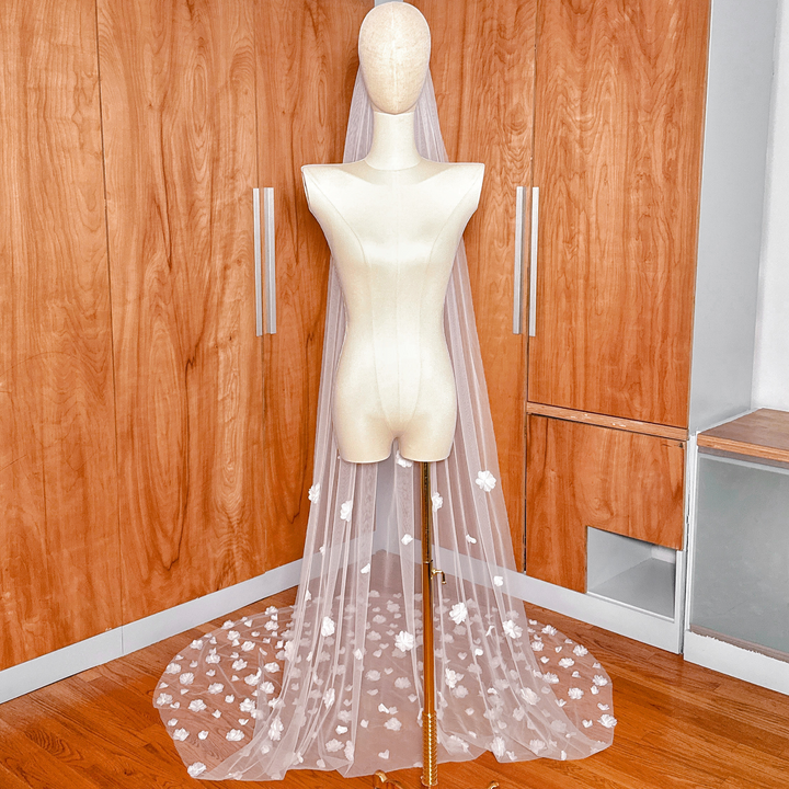 Wide shot of the allover 3D floral wedding veil cathedral length spread out at the base of a mannequin to show the full floral pattern.