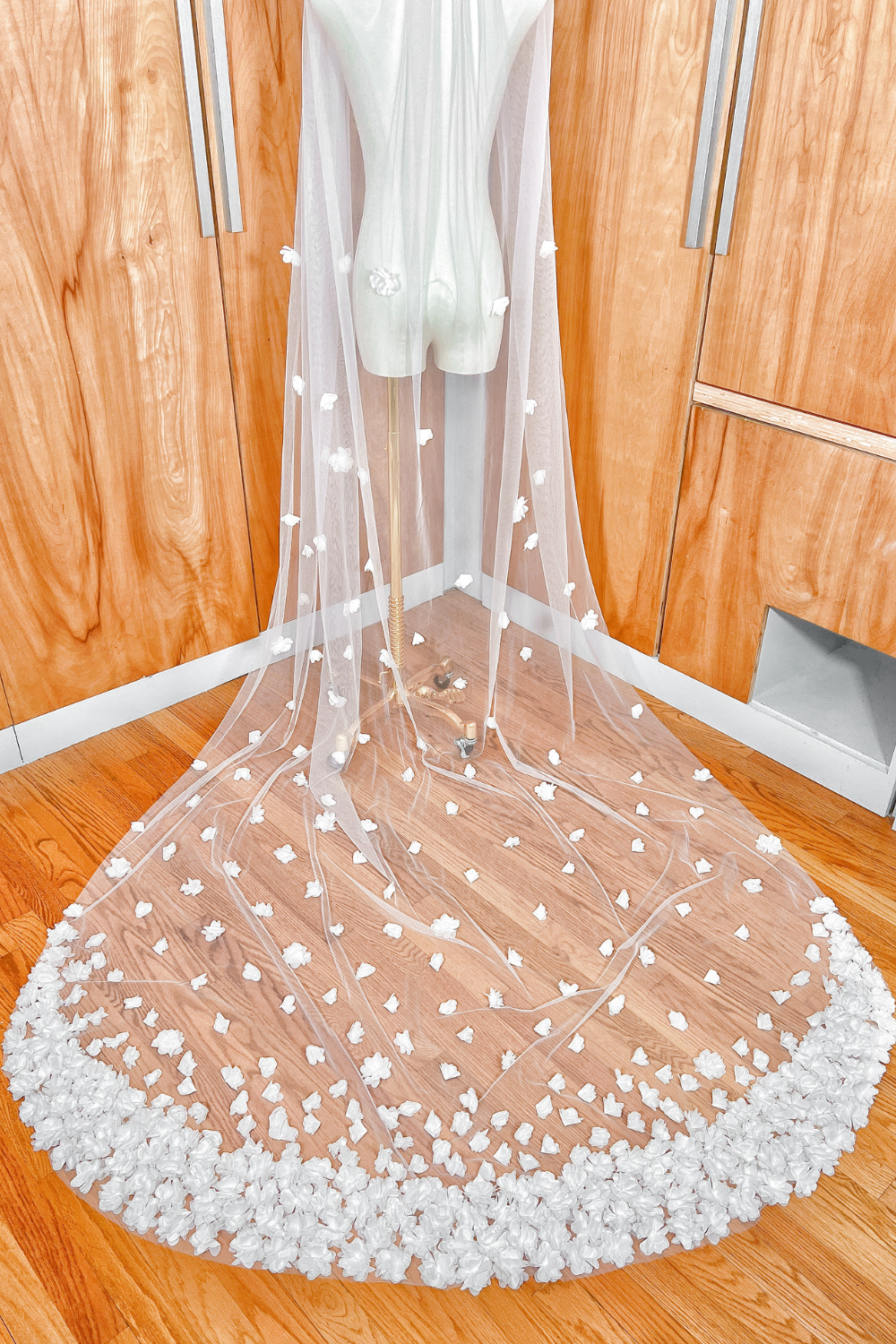 Soft tulle texture and 3D floral pattern on the long train of a cathedral length wedding veil.