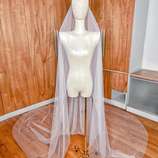 A dramatic cathedral length wedding veil featuring allover pearl embellishments and a long sweeping train.
