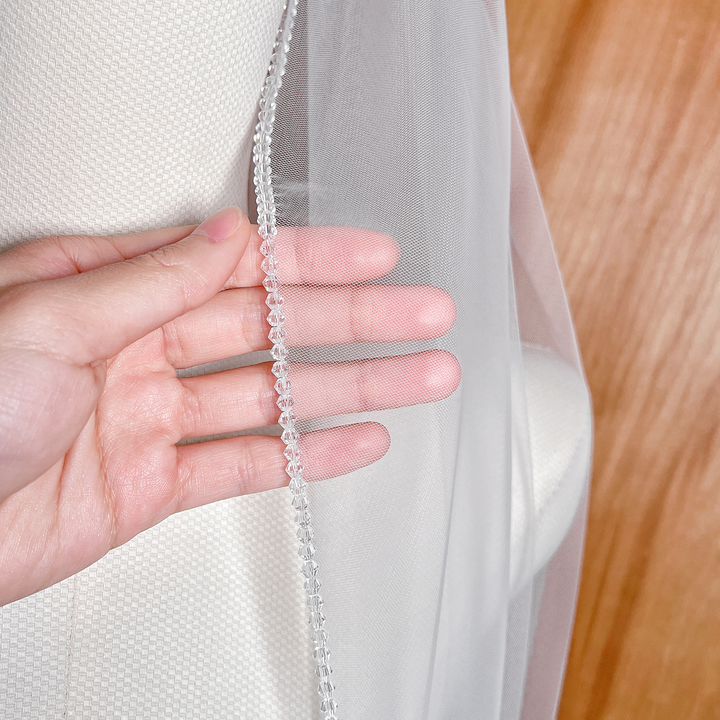 Close-up detail of the intricate sparkling crystal trim on an Angel Cut bridal wedding veil.