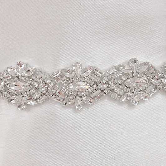 Close-up of an Art Deco beaded bridal belt featuring intricate geometric pearl and rhinestone patterns on a bridal mannequin.