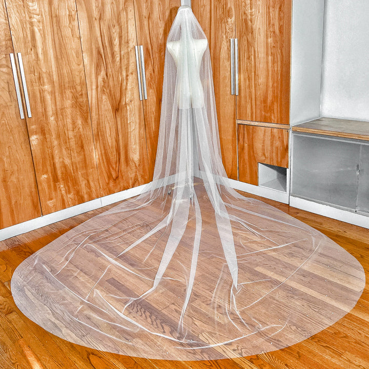 Rear view of a wedding veil with cascading scattered pearls on sheer ivory tulle in a dramatic royal cathedral length.
