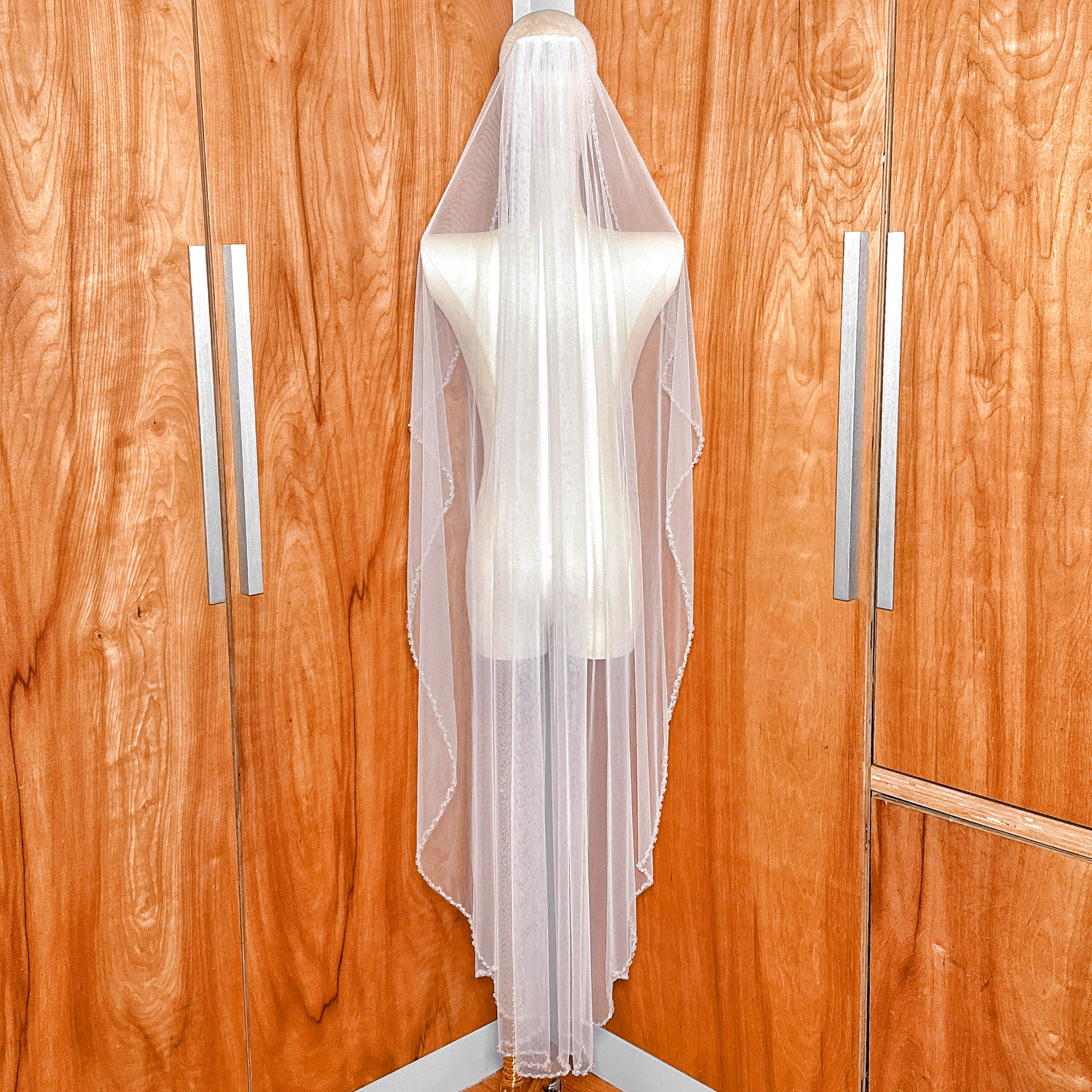 Back view of a waltz length crystal beaded edge wedding veil draping elegantly.