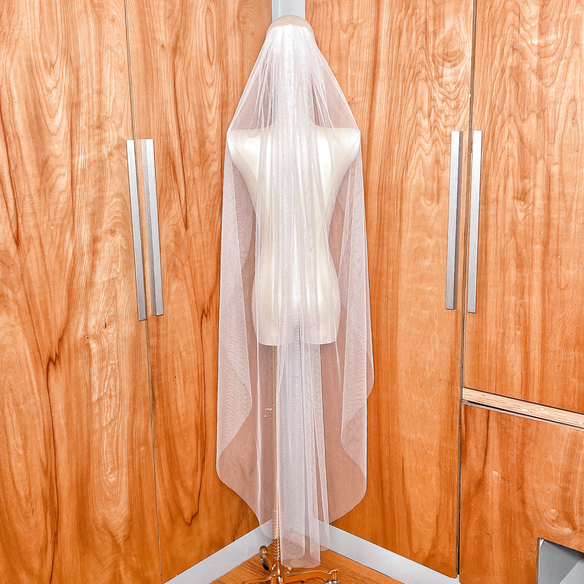 Back view showing the graceful drape of a waltz length English net wedding veil with no trim.