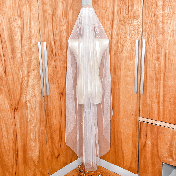 Back view showing the graceful drape of a waltz length English net wedding veil with no trim.