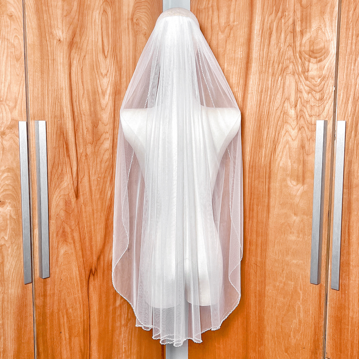 Back view of a fingertip length wedding veil illustrating how the pearl and crystal beaded edge drapes elegantly.