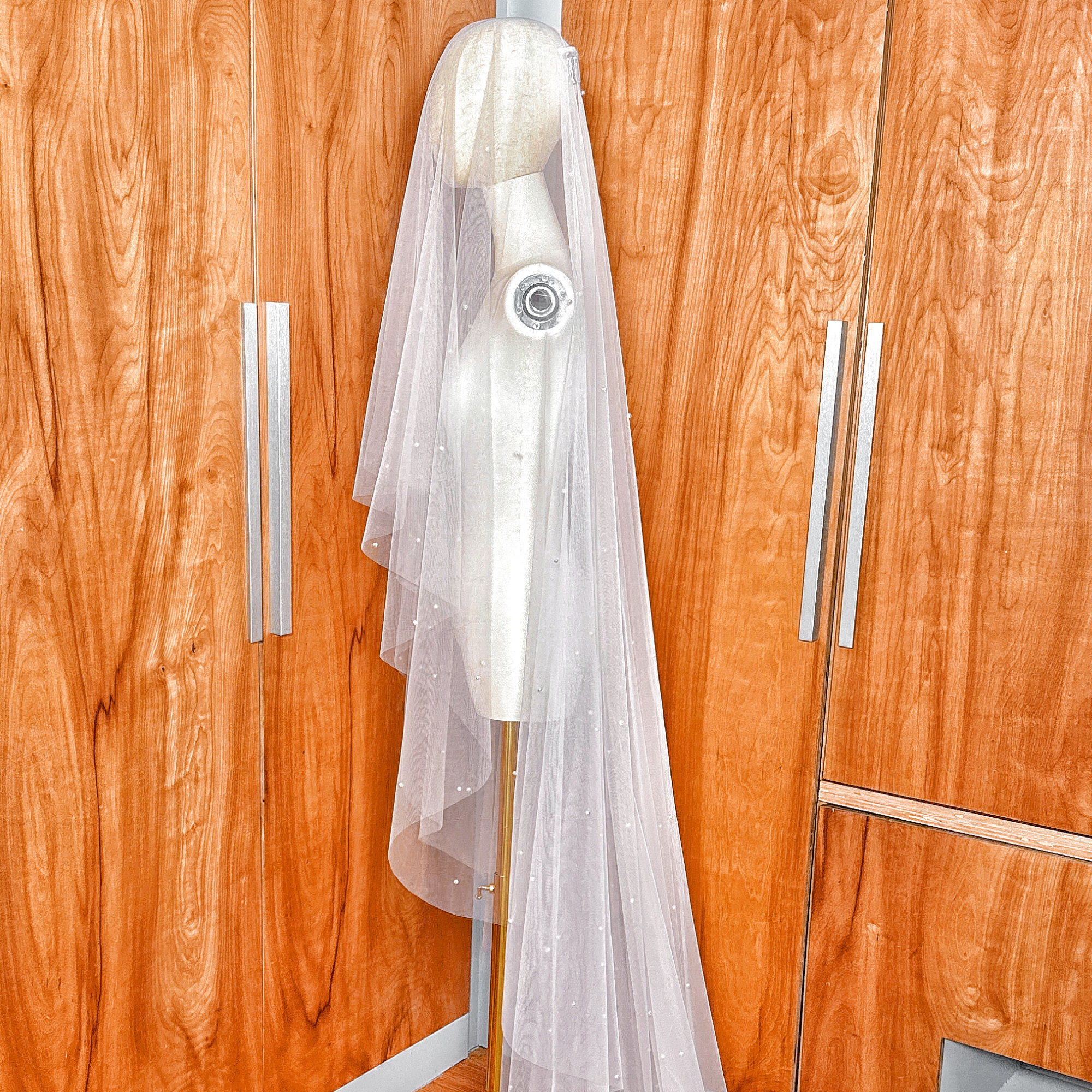 Back view of a cathedral length scattered pearl wedding veil showing the two tier drop veil drape.