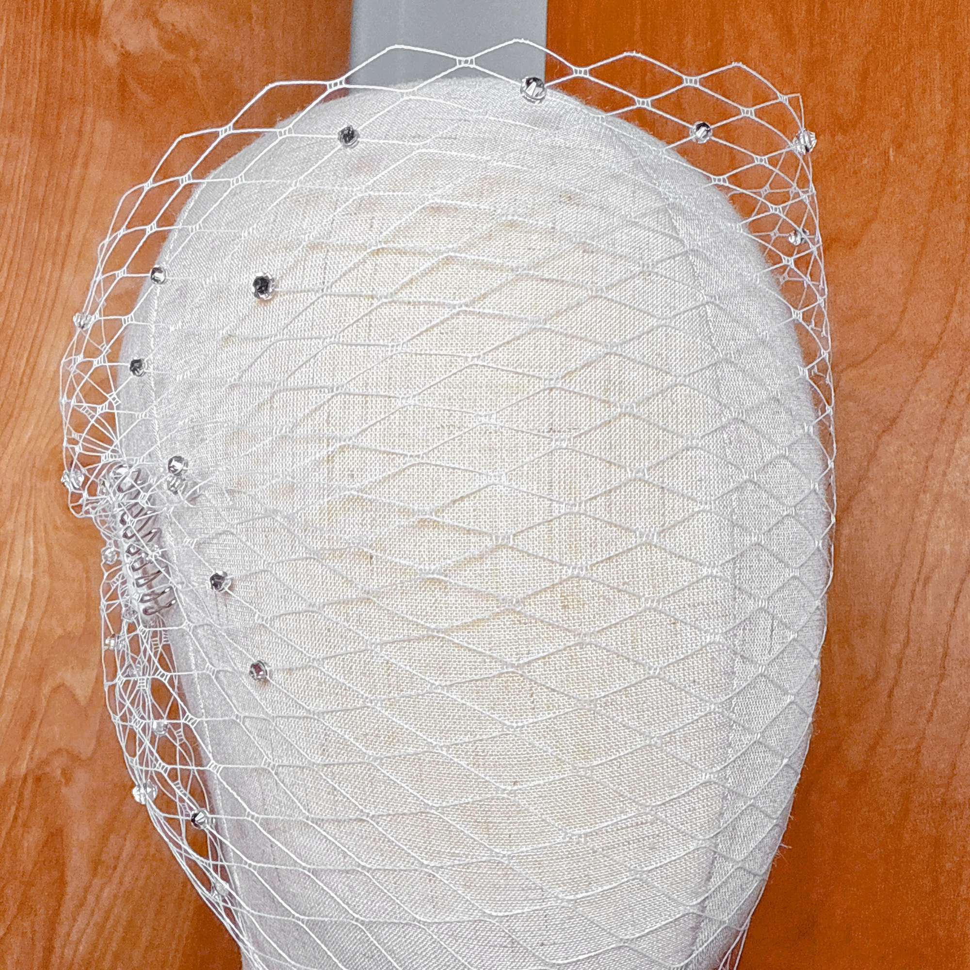 Close-up of a tulle bandeau birdcage wedding veil with rhinestones.