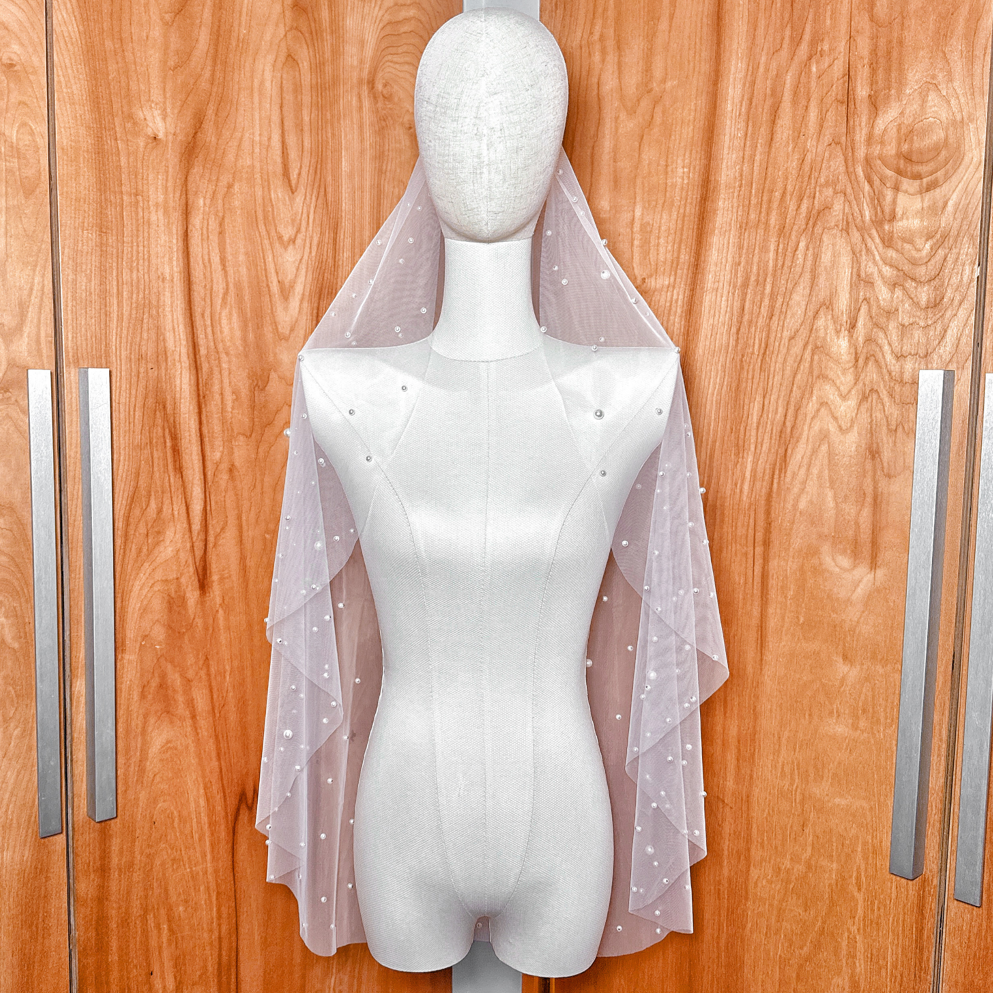 Front view of the fingertip-length Barely There Scattered Pearl Wedding Veil showing the light distribution of pearls on soft ivory tulle.